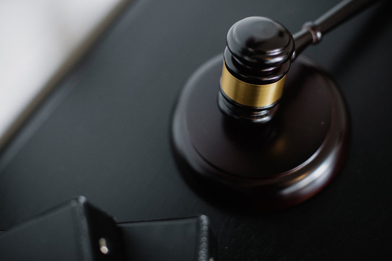 about-us From above of wooden gavel on round surface near folders on table in courtroom